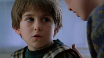 Movie still from “New Nightmare” (1994), directed by Wes Craven – A young boy looking at a woman with a concerned look on his face; Close Up shot, Over the shoulder angle