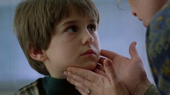 Movie still from “New Nightmare” (1994), directed by Wes Craven – A woman touching a young boy's face with her hand; Close Up shot, Low angle