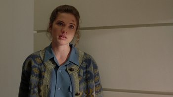 Movie still from “New Nightmare” (1994), directed by Wes Craven – A woman in a blue shirt and a blue and yellow jacket; Close Up shot, Over the shoulder angle