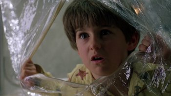 Movie still from “New Nightmare” (1994), directed by Wes Craven – A young boy is looking at the camera through an umbrella; Close Up shot, Low angle