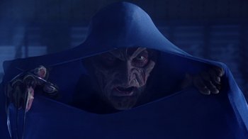 Movie still from “New Nightmare” (1994), directed by Wes Craven – An evil looking man in a blue hooded robe; Close Up shot, Low angle
