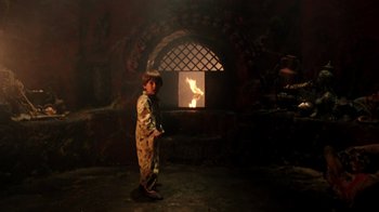 Movie still from “New Nightmare” (1994), directed by Wes Craven – A young boy standing in front of an open fire; Wide shot, Low angle