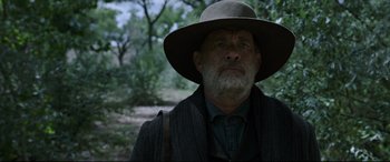 Movie still from “News of the World” (2020), directed by Paul Greengrass – An older man wearing a hat in a wooded area; Close Up shot, Over the shoulder angle