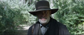 Movie still from “News of the World” (2020), directed by Paul Greengrass – An old man with a gray beard wearing a hat; Close Up shot, Low angle