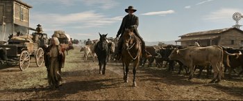 Movie still from “News of the World” (2020), directed by Paul Greengrass – A man on a horse herds a herd of cattle; Wide shot, Low angle