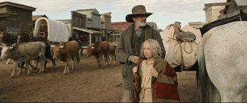 Movie still from “News of the World” (2020), directed by Paul Greengrass – An older man and a young girl in a cowboy outfit; Medium shot, Low angle