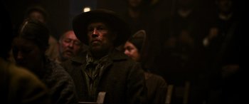 Movie still from “News of the World” (2020), directed by Paul Greengrass – A man wearing a hat and a coat; Medium shot, Over the shoulder angle