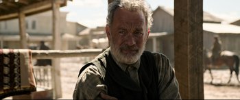 Movie still from “News of the World” (2020), directed by Paul Greengrass – An older man with a beard and a tie; Close Up shot, Over the shoulder angle