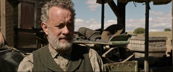 Movie still from “News of the World” (2020), directed by Paul Greengrass – An older man with a beard is standing in front of a pile of trash; Close Up shot, Over the shoulder angle