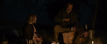Movie still from “News of the World” (2020), directed by Paul Greengrass – A man and a woman sitting in the dark outside; Medium shot, Over the shoulder angle