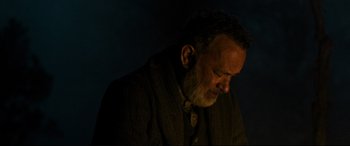Movie still from “News of the World” (2020), directed by Paul Greengrass – An older man with a goatee is looking down at his head; Close Up shot, Low angle