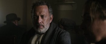 Movie still from “News of the World” (2020), directed by Paul Greengrass – An older man with a beard and a gray coat; Close Up shot, Over the shoulder angle