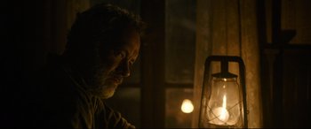 Movie still from “News of the World” (2020), directed by Paul Greengrass – A person sitting at a table; Close Up shot, Low angle