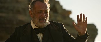 Movie still from “News of the World” (2020), directed by Paul Greengrass – An older man with a beard and a bow tie; Close Up shot, Over the shoulder angle