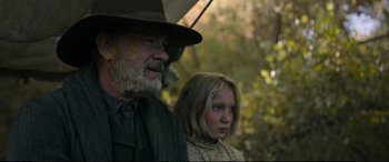 Movie still from “News of the World” (2020), directed by Paul Greengrass – An older man and a young girl are standing in the woods; Close Up shot, Low angle