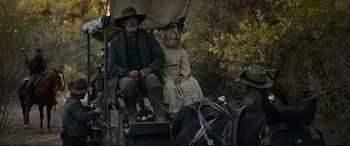 Movie still from “News of the World” (2020), directed by Paul Greengrass – A man and a woman sitting in a carriage on the side of the road; Wide shot, Low angle