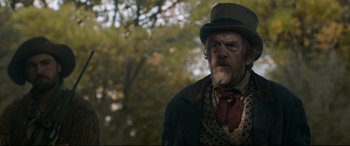 Movie still from “News of the World” (2020), directed by Paul Greengrass – An old man wearing a top hat and a tie; Medium shot, Low angle