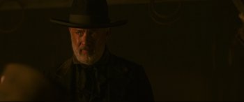 Movie still from “News of the World” (2020), directed by Paul Greengrass – An older man wearing a hat and a tie; Close Up shot, Over the shoulder angle