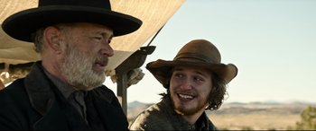 Movie still from “News of the World” (2020), directed by Paul Greengrass – A man in a cowboy hat is talking to another man in a cowboy hat; Close Up shot, Over the shoulder angle