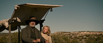 Movie still from “News of the World” (2020), directed by Paul Greengrass – An older man and a young girl under an umbrella; Medium shot, Low angle