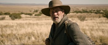 Movie still from “News of the World” (2020), directed by Paul Greengrass – An older man in a hat and a coat; Medium shot, Over the shoulder angle