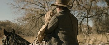 Movie still from “News of the World” (2020), directed by Paul Greengrass – An older man holding a young girl in his arms; Medium shot, Over the shoulder angle