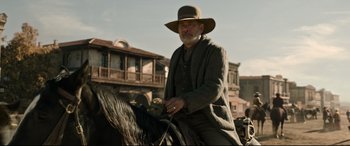 Movie still from “News of the World” (2020), directed by Paul Greengrass – A man riding on the back of a black horse; Medium shot, Low angle