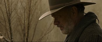 Movie still from “News of the World” (2020), directed by Paul Greengrass – A person wearing a hat with a tree in the background; Close Up shot, Low angle