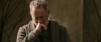 Movie still from “News of the World” (2020), directed by Paul Greengrass – An older man with grey hair and a gray beard is holding his hands to his face; Close Up shot, Over the shoulder angle