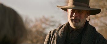 Movie still from “News of the World” (2020), directed by Paul Greengrass – An older man wearing a hat and a scarf; Close Up shot, Low angle