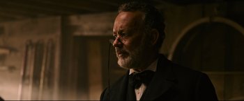 Movie still from “News of the World” (2020), directed by Paul Greengrass – An older man wearing a black suit and a black bow tie; Close Up shot, Low angle
