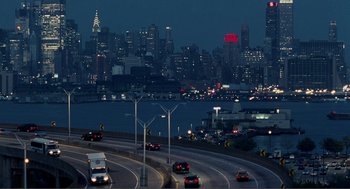 Movie still from “Nick and Norah's Infinite Playlist” (2008), directed by Peter Sollett – Cars are driving on a highway near a city at night; Extreme Wide shot, High angle