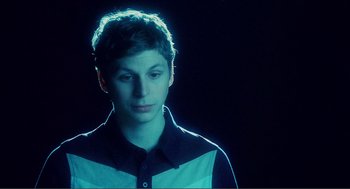 Movie still from “Nick and Norah's Infinite Playlist” (2008), directed by Peter Sollett – A young man is standing in the dark; Close Up shot, Over the shoulder angle