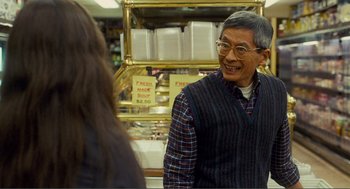 Movie still from “Nick and Norah's Infinite Playlist” (2008), directed by Peter Sollett – An older man is talking to a woman in a store; Medium shot, Over the shoulder angle