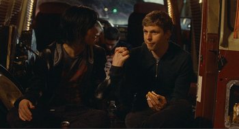 Movie still from “Nick and Norah's Infinite Playlist” (2008), directed by Peter Sollett – A man and a woman sitting on a couch; Medium shot, Over the shoulder angle