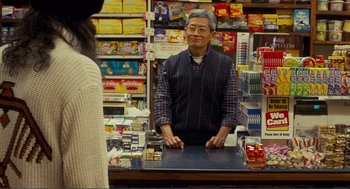 Movie still from “Nick and Norah's Infinite Playlist” (2008), directed by Peter Sollett – A man standing behind a counter in front of a woman; Medium shot, Over the shoulder angle