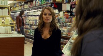 Movie still from “Nick and Norah's Infinite Playlist” (2008), directed by Peter Sollett – A woman standing in front of a shelf in a grocery store; Medium shot, Over the shoulder angle
