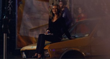 Movie still from “Nick and Norah's Infinite Playlist” (2008), directed by Peter Sollett – A woman sitting on the hood of a taxi cab; Wide shot, Low angle