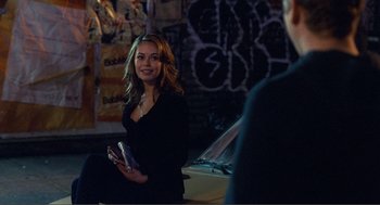 Movie still from “Nick and Norah's Infinite Playlist” (2008), directed by Peter Sollett – A woman in black shirt holding a cell phone in her hand; Medium shot, Over the shoulder angle