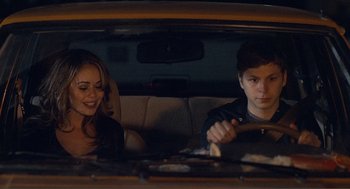 Movie still from “Nick and Norah's Infinite Playlist” (2008), directed by Peter Sollett – A man and a woman sitting in the back seat of a car; Medium shot, Over the shoulder angle