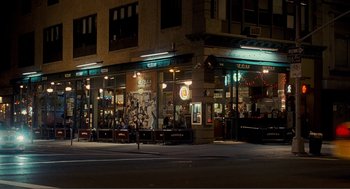 Movie still from “Nick and Norah's Infinite Playlist” (2008), directed by Peter Sollett – A man riding a bike down a street at night; Extreme Wide shot, High angle