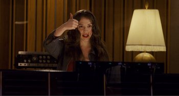 Movie still from “Nick and Norah's Infinite Playlist” (2008), directed by Peter Sollett – A woman is sitting at a piano with her hand raised up; Medium shot, High angle