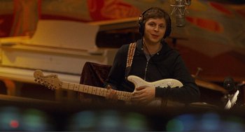 Movie still from “Nick and Norah's Infinite Playlist” (2008), directed by Peter Sollett – A man with a guitar in a recording studio; Close Up shot, Over the shoulder angle