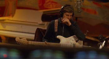 Movie still from “Nick and Norah's Infinite Playlist” (2008), directed by Peter Sollett – A man with a guitar in a recording studio; Medium shot, High angle