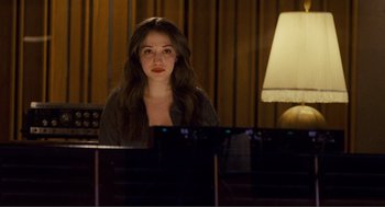 Movie still from “Nick and Norah's Infinite Playlist” (2008), directed by Peter Sollett – A woman sitting in front of a piano in front of a lamp; Close Up shot, High angle