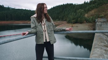 Movie still from “Night Moves” (2013), directed by Kelly Reichardt – A woman standing next to a body of water; Wide shot, Low angle