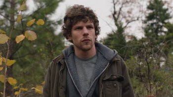 Movie still from “Night Moves” (2013), directed by Kelly Reichardt – A man with curly brown hair wearing a jacket; Close Up shot, Over the shoulder angle