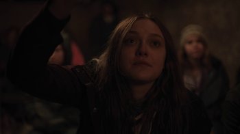 Movie still from “Night Moves” (2013), directed by Kelly Reichardt – A woman with long brown hair is looking at the camera; Medium shot, Over the shoulder angle