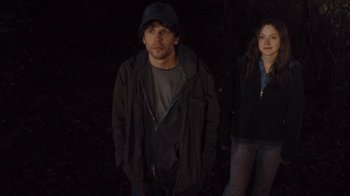 Movie still from “Night Moves” (2013), directed by Kelly Reichardt – A man and a woman standing next to each other in the dark; Medium shot, Low angle