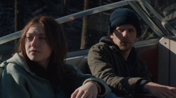 Movie still from “Night Moves” (2013), directed by Kelly Reichardt – A man and a woman sitting in the back of a car; Medium shot, Low angle